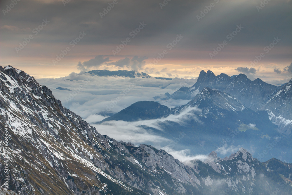 Obraz premium Rolling fog and sun rays above Wertatscha Vrtaca and Koschutnikturm Kosutnikov Turn peaks of Koschuta Kosuta ridge in Karawanken Karavanke range from Hochstuhl Stol Carinthia Austria / Slovenia Europe