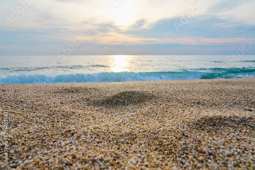 Sandy beach with blurred sea on a background on a sunset.  