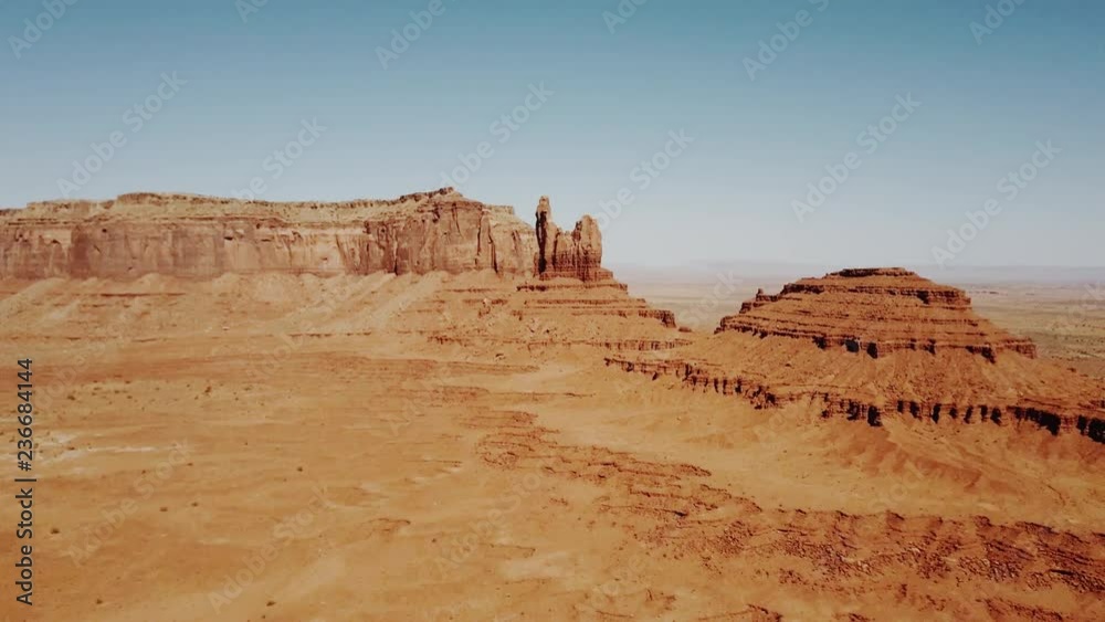 Drone flying over sunny dry desert towards big rocky mountains and clear blue sky in Monument Valley national park. Drone flying over sunny dry desert towards big rocky mountains and clear blue sky in Monument Valley national park.