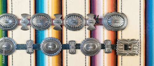 Sterling Silver Native American Concho Belt on Brightly Colored Southwestern Pattern Fabric. photo