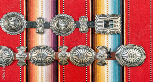 Sterling Silver Native American Concho Belt on Brightly Colored Southwestern Pattern Fabric.