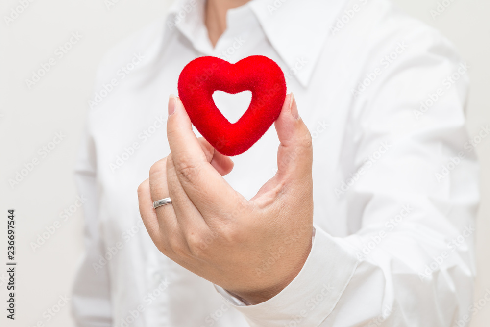 Woman's hand holding a heart shape Woman's hand holding a heart shape