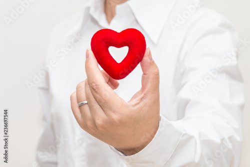 Woman's hand holding a heart shape