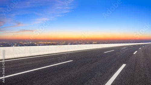 Empty asphalt road and modern city skyline at night © ABCDstock