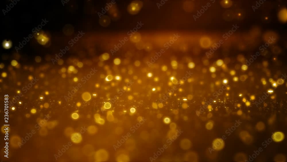 Soft-focused golden particles falling and bouncing on the glossy surface. FullHD 1080p.