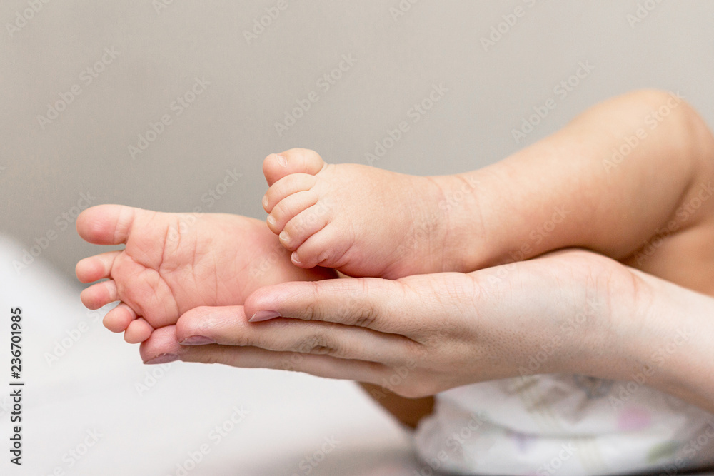 Mother is giving a massage to her newborn son Mother is giving a massage to her newborn son