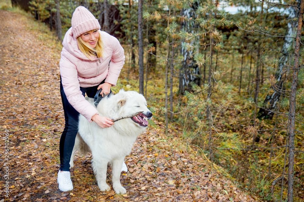 A pretty woman is walking her dog A pretty woman is walking her dog