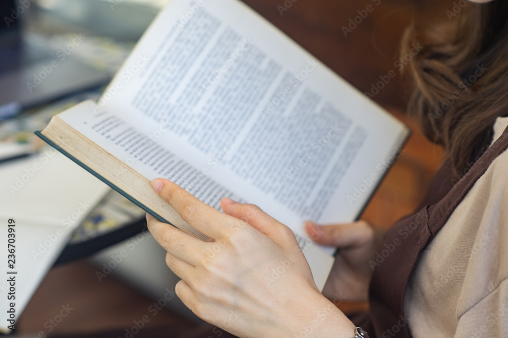 Fototapeta premium Closeup woman hand holding a book to read