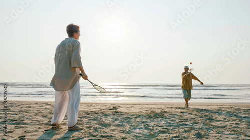 Active senior couple playing tai chi ballon ball at the beach. photo