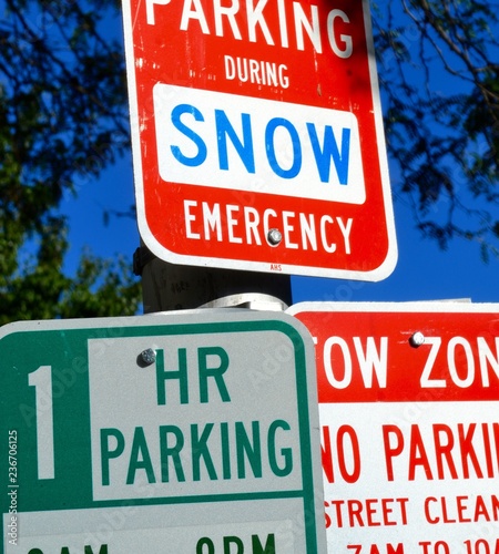 Photography Warning and information street signs for parking and snow emergency on road in B