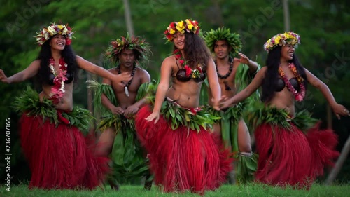 Young males and females in a group of Tahitian hula dancers performing outdoor barefoot in traditional costume Tahiti French Polynesia South Pacific photo