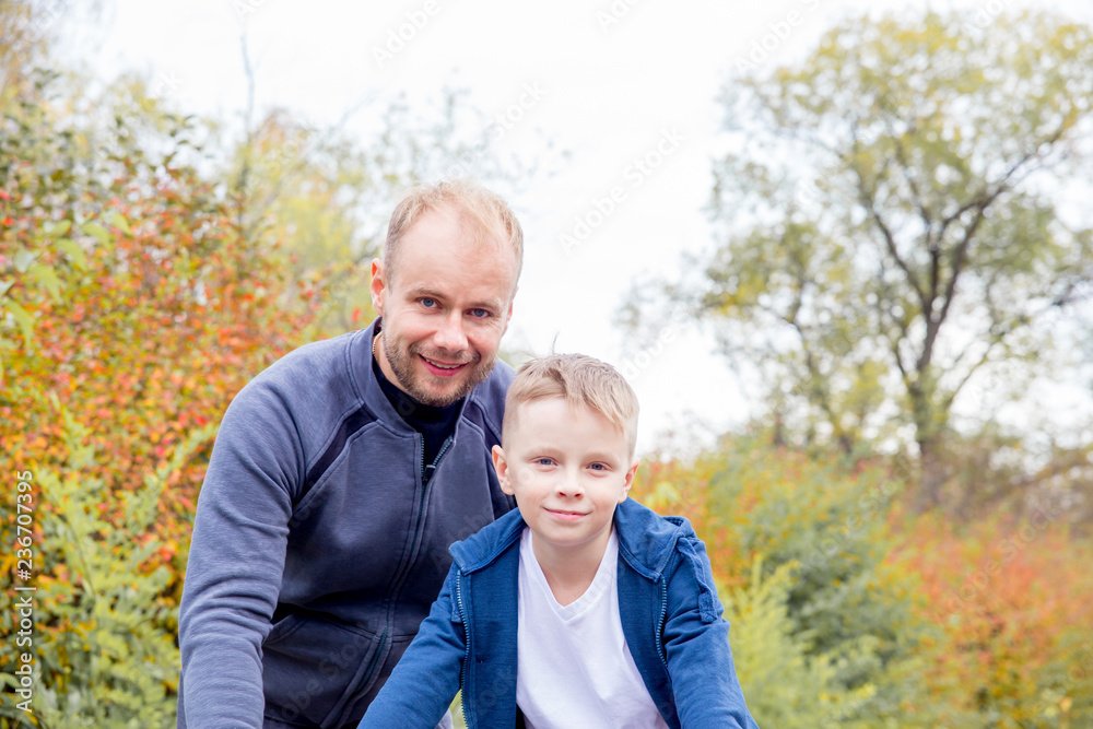 Father teaching his son to ride a bike in a park