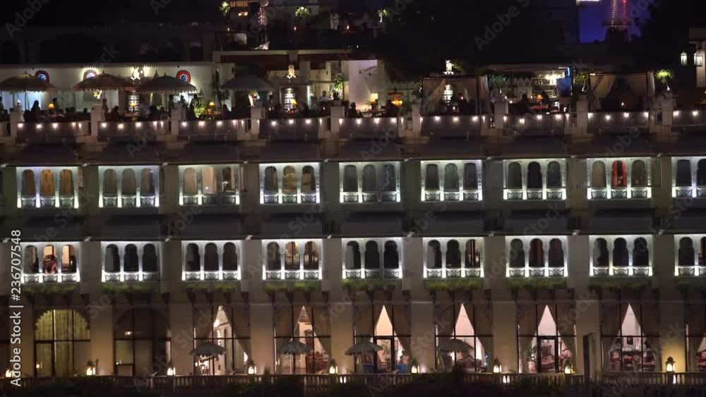 UDAIPUR, INDIA - NOVEMBER 21, 2018 : Night view on architecture and lake water in Udaipur, Rajasthan, India. Establishing shot. Udaipur is one of the most visited tourist destinations in India.
