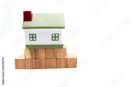 Miniature model house on fundation of wooden cubes, isolated on white photo