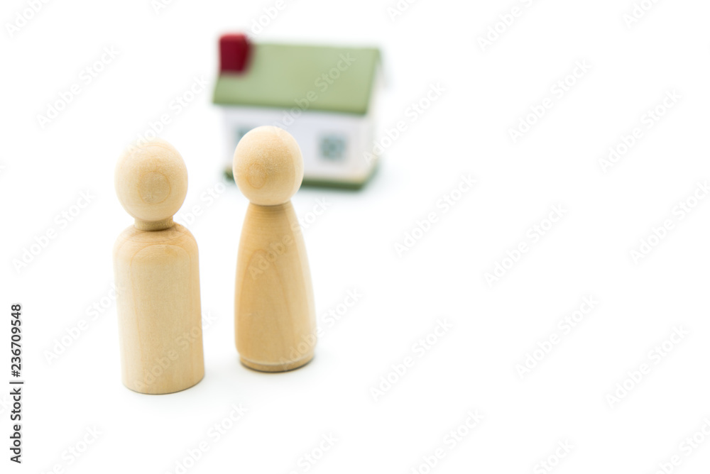Wooden figures as family concept with house in the background, isolated on white