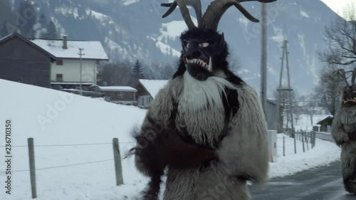 Two Traditional Krampus run in Gastein Austria. Folklore during christmas in Salzburg. Mountain village demons with masks and horn during advent. Saint Nicholas and his krampus. Bavarian demons. photo