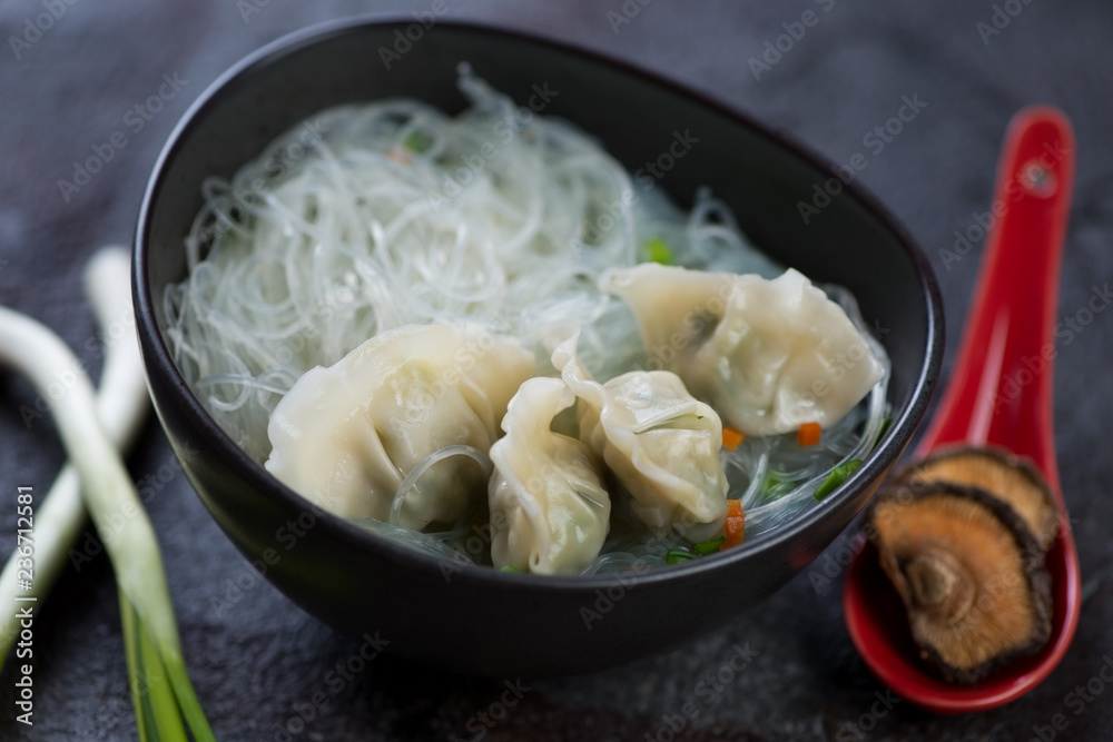 Bowl of wonton soup with funchoza noodles, selective focus, horizontal shot Bowl of wonton soup with funchoza noodles, selective focus, horizontal shot