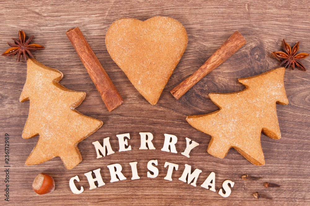 Fresh baked gingerbreads, inscription Merry Christmas and spices for baking Fresh baked gingerbreads, inscription Merry Christmas and spices for baking
