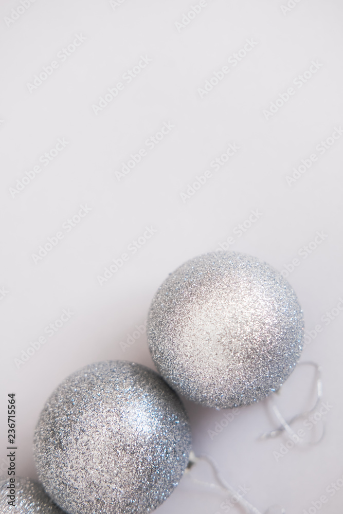 White Christmas background. Glossy silver and glitter decoration balls. Minimalist style. Copyspace for text, overhead White Christmas background. Glossy silver and glitter decoration balls. Minimalist style. Copyspace for text, overhead