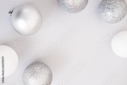 White Christmas background. Glossy silver and glitter decoration balls. Minimalist style. Copyspace for text  overhead