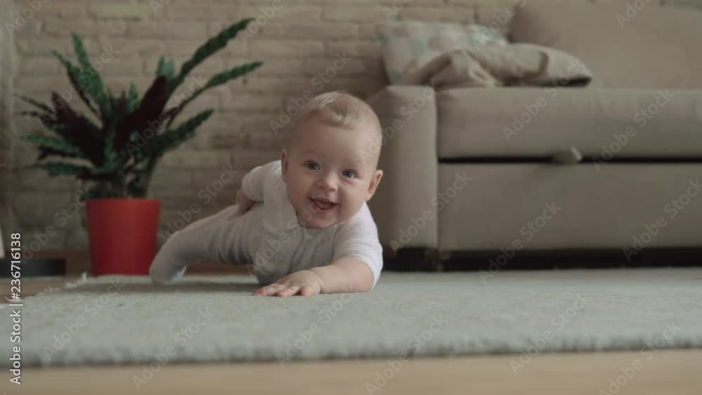 Medium shot of an adorable baby girl playing on the carpet of her living room at home. Filmed from the floor Medium shot of an adorable baby girl playing on the carpet of her living room at home. Filmed from the floor