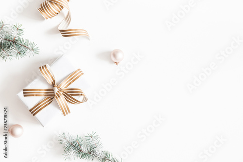 Christmas composition. Gift, fir tree branches, balls on white background. Christmas, winter, new year concept. Flat lay, top view, copy space