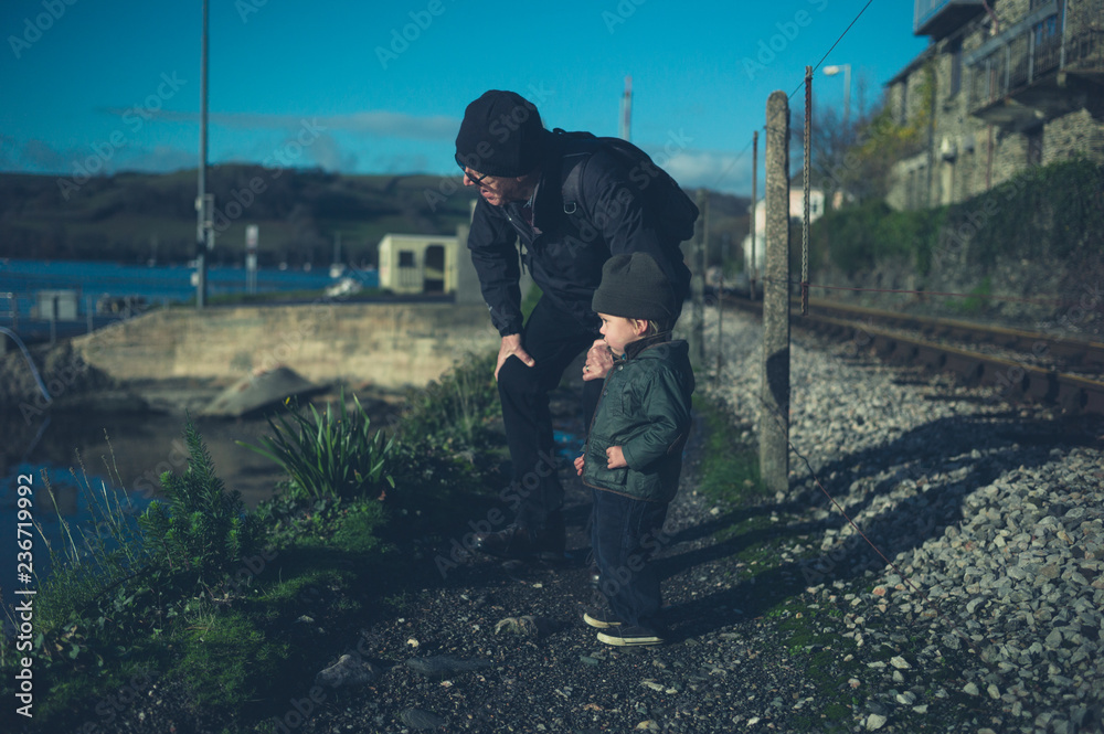 Grandfather and toddler walking by railway tracks Grandfather and toddler walking by railway tracks