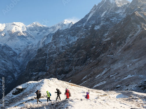 Annapurna region,Nepal - November 15,2018 : group of hikers reaches the mountain peak of Machapuchare. A mountain in the Annapurna Himalayas of north central Nepal