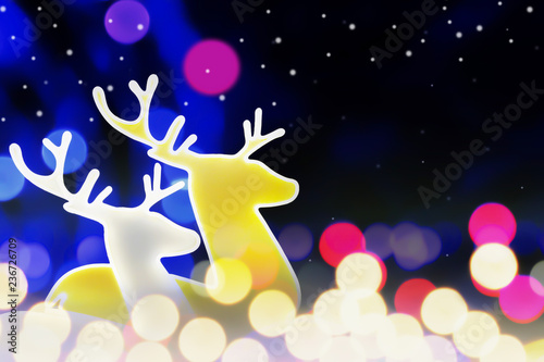 Christmas golden reindeer on fantasy gold Bright light and colorful holiday bokeh background with beautiful blue pattern and snow at night sky. © ekapolsira