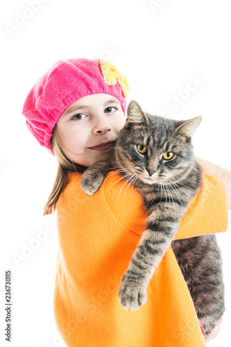 Little girl in a red Christmas hat gnome with a striped cat on a white isolated background.