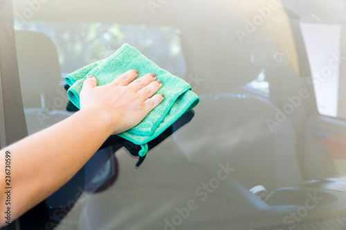 Women are wiping the car glass with microfiber textile