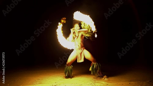 Male Fire dancer with illuminated spinning flaming torch performing the Art of Fire dancing a traditional culture in French Polynesia South Pacific photo