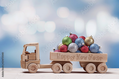 Toy car with christmas balls on festive background.