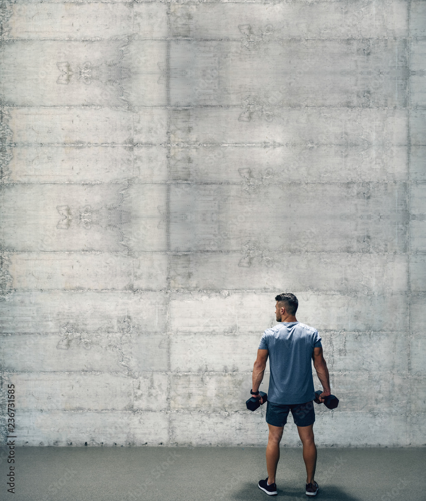 Man holding dumbbells while standing with backs turned. You don't get what you want, you get what you work for. Man holding dumbbells while standing with backs turned. You don't get what you want, you get what you work for.