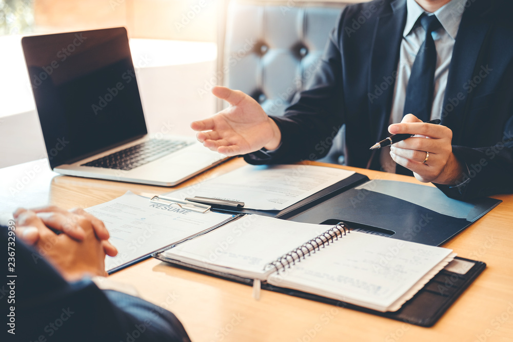 Senior manager reading a resume during a job interview employee young man meeting Applicant and recruitment concept Senior manager reading a resume during a job interview employee young man meeting Applicant and recruitment concept