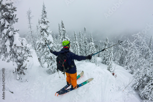 Man splitboard freerider standing at top of ridge. Ski touring in mountains, winter freeride extreme sport