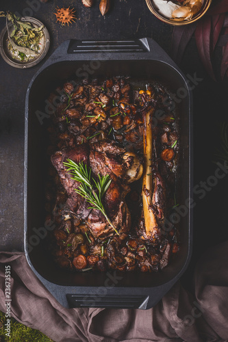 Fotografiet Slow cooked venison roast in black cast iron pan, top view