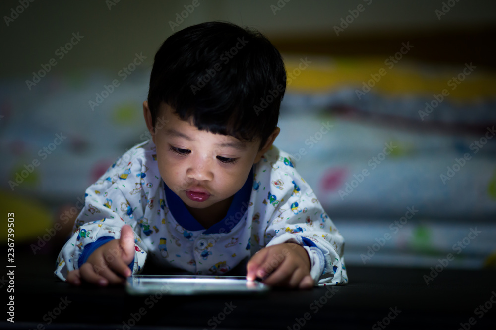 children play games on a smartphone at night children play games on a smartphone at night