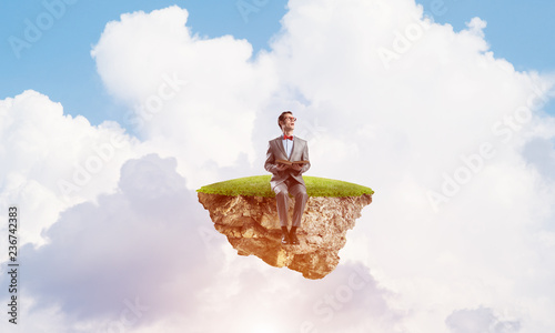 Young businessman or student floating in sky and studying the science