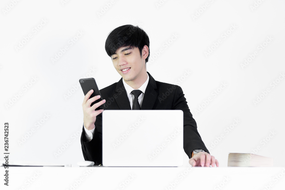 Asian manager businessman sitting at desk and using with phone, isolated on white background. Asian manager businessman sitting at desk and using with phone, isolated on white background.