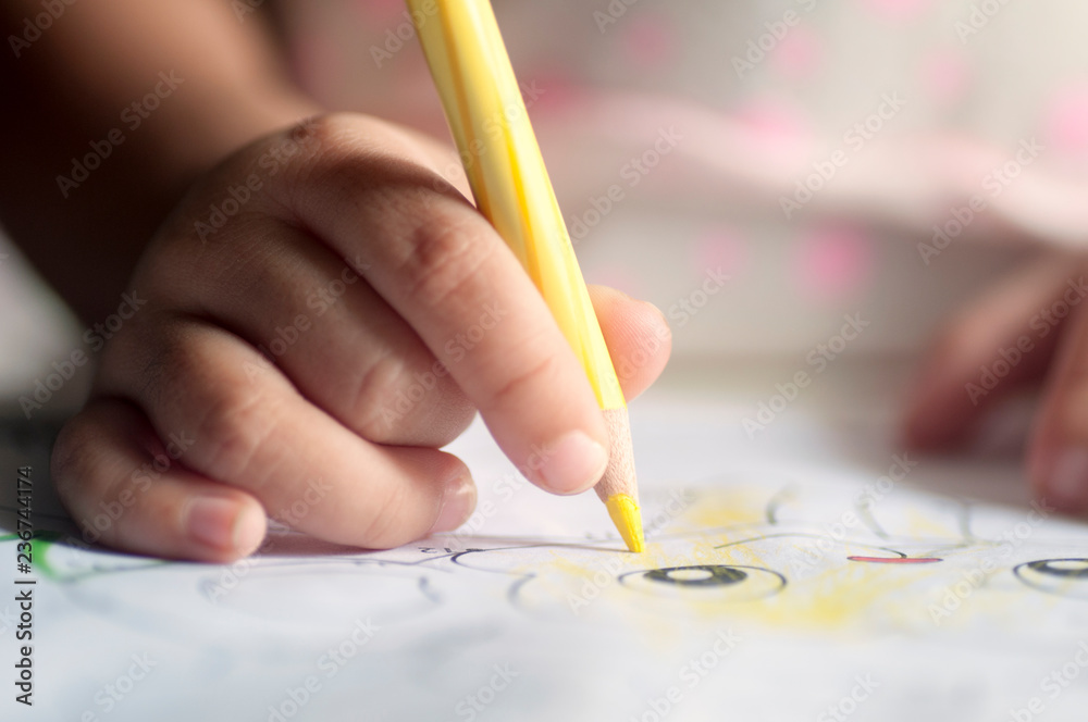 Close up of the hands of a little child use color pencils Close up of the hands of a little child use color pencils