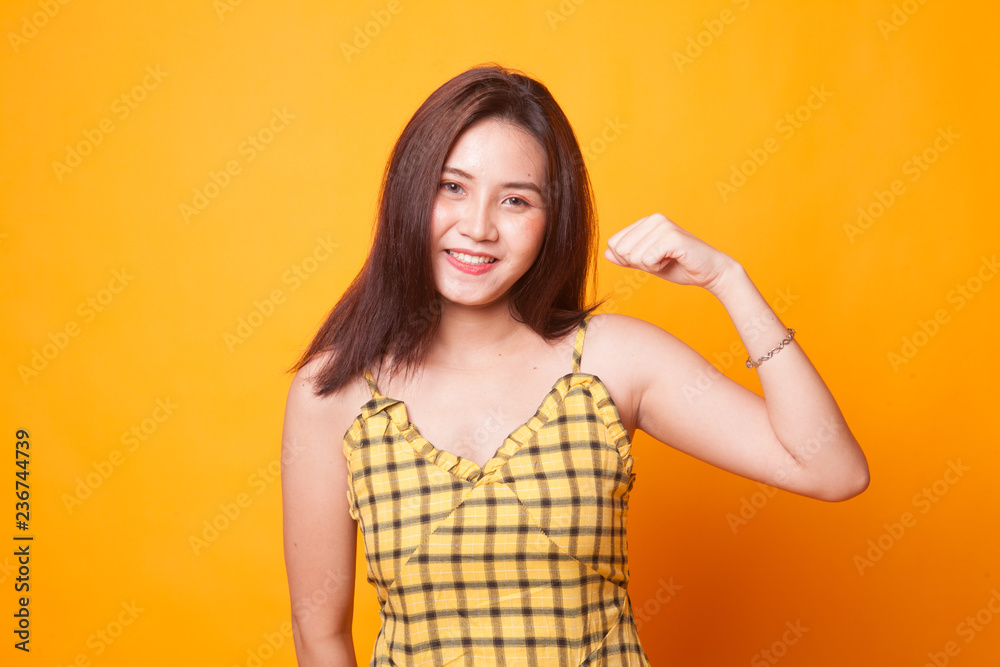 Fototapeta premium Beautiful young Asian woman flex bicep.