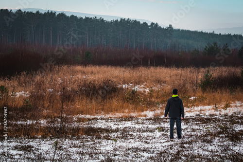 Young man standing landscape with snow and distant hills