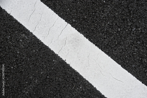 駐車場のアスファルトに斜めにひかれた白線 © Spica