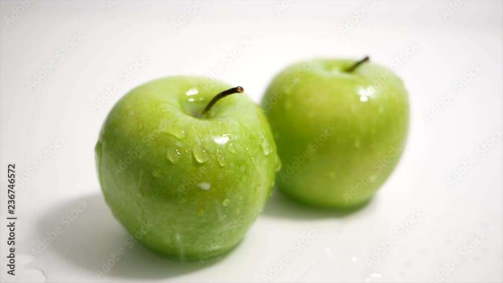 Green apples on white background splashed with drops of water. Green apples on white background splashed with drops of water.