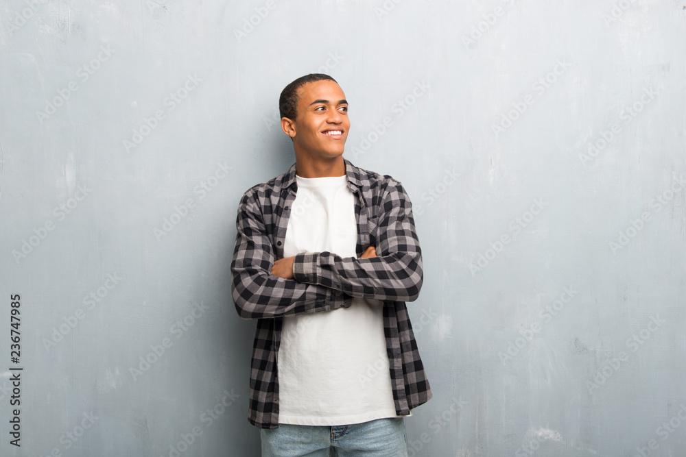 Young african american man with checkered shirt looking up while smiling