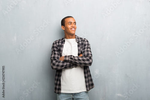 Young african american man with checkered shirt looking up while smiling