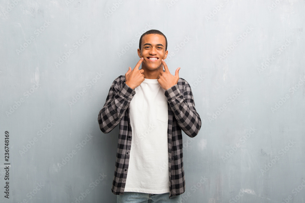 Young african american man with checkered shirt smiling with a happy and pleasant expression