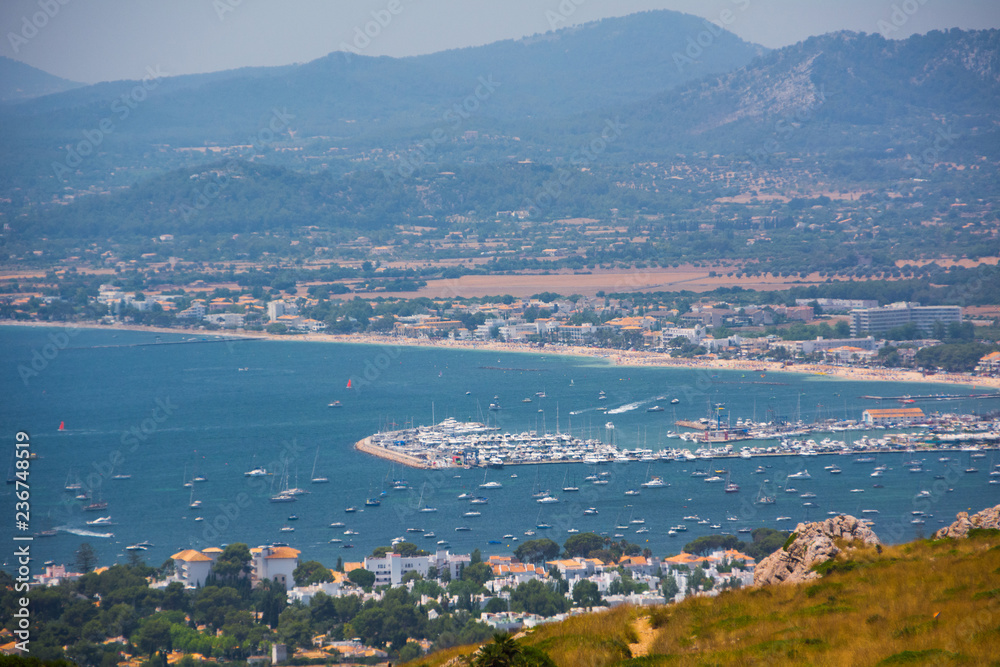 Port de Pollensa, Mallorca, Spain - July 19, 2013: View from Cape Formentor on the city, yachts, beach, streets, hotels.