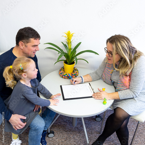 Father and toddler daughter in therapist office during counselling assesment meeting. photo